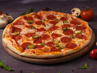 spicy pizza with pepperoni and jalapeno on a wooden Board