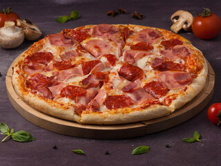 meat pizza with ham, bacon, and pepperoni on a wooden Board