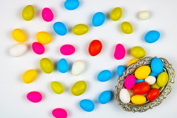 Colorful candies on the white background and the bowl