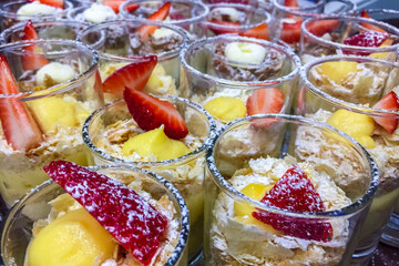 Desserts in transparent glass glasses decorated with cream and fruit.