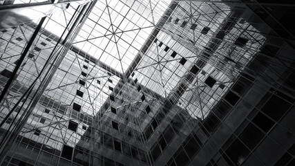 The glass dome of the office building and the mirrored facade reflecting the sky and elements of the structure of the building,View from inside the building.