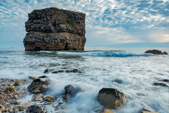 Marsden Rock. South Shields, England, in early morning light. With waves washing over the beach and rocks.