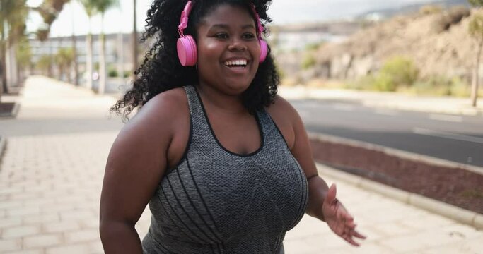 Curvy girl running outdoor - Plus size body, sport and healthy lifestyle concept