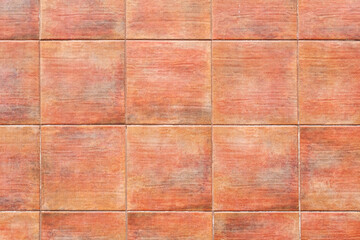 Textured background with a tiled wall with seams, wall in orange color