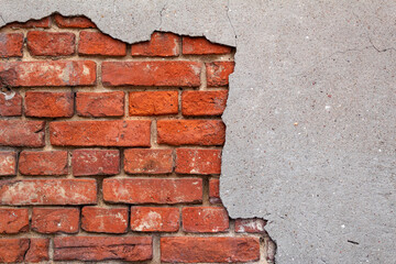 Broken wall with red bricks in close-up, gray-red background, texture