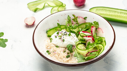 Vegan breakfast oatmeal porridge, poached egg with vegetable salad of radish, cucumbers and arugula. Healthy vegan food, top view