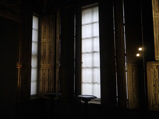 A picture of a vintage european window  A warm light shone through the white curtains.