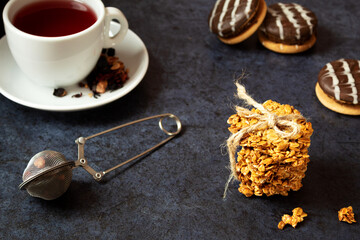 Obraz na płótnie Canvas Cookies, oatmeal cookies, with tea, on a dark textured background, sweet breakfast, brewed tea, top view, still life