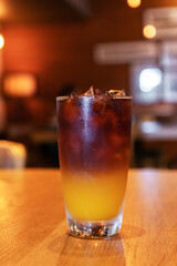 Iced fresh orange juice topped with espresso on wooden table; as sunrise coffee make a good day.