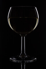 White wine in a glass on a black background