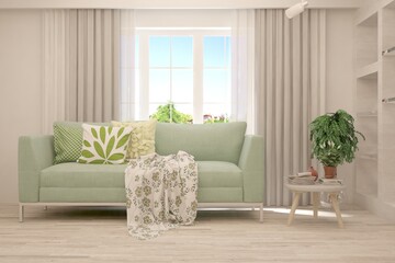 White living room with sofa and summer landscape in window. Scandinavian interior design. 3D illustration