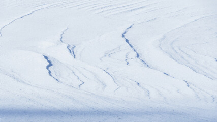 Fototapeta na wymiar shadows and textures on white snow in winter