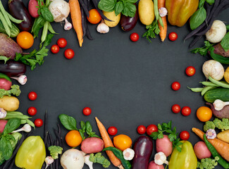 Frame of various  vegetables on dark background, top view.