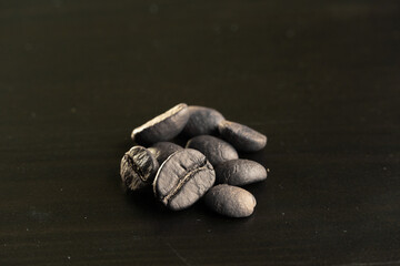 several black coffee beans on a black background