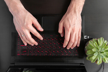 male hands over laptop from above