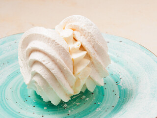 sweet meringue cake on a blue plate on a light background