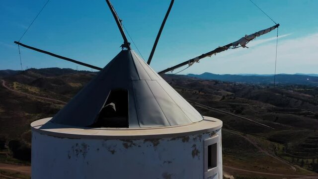 Aerial view of an old wind mill in south Europe. A close up of the wind mill in Silves, Portugal on a sunny day with a deep blue sky in the background. 