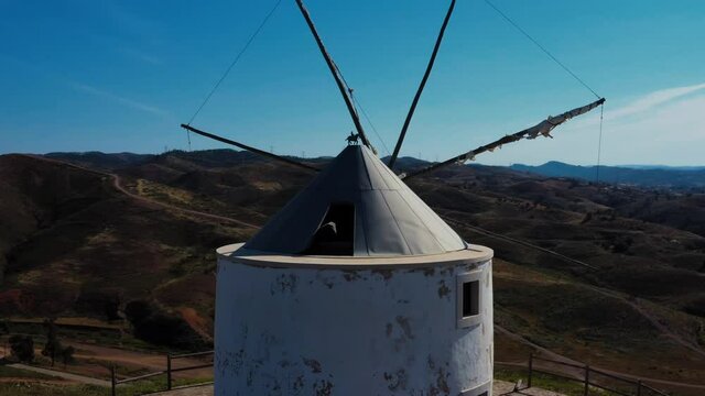 Aerial view of an old wind mill in south Europe. A close up of the wind mill in Silves, Portugal on a sunny day with a deep blue sky in the background. 