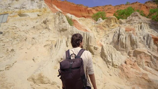A man tourist visits the red canyon or Fairy stream at the border of desert in the Mui Ne village in southern Vietnam