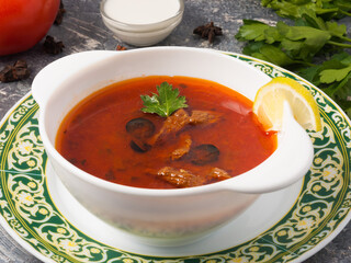 soup Solyanka in a white plate close up