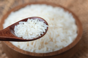 rice in a wooden spoon. top view and copy space, organic rice, and healthy food