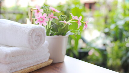 close up ofTowel placed on basket, white table top, bottle of liquid soap, spa set for bathing in the bathroom, copy space, bathroom window.