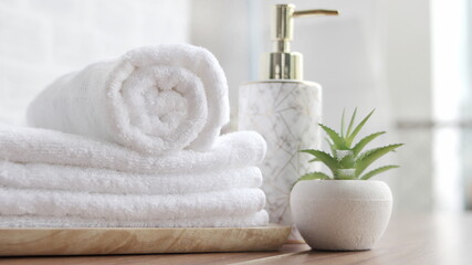 close up ofTowel placed on basket, white table top, bottle of liquid soap, spa set for bathing in the bathroom, copy space, bathroom window.
