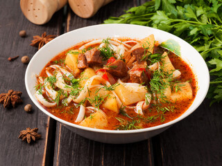 lagman with beef in a white plate on a wooden background