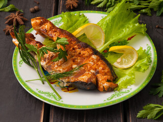 grilled salmon steak on a white plate with lemon