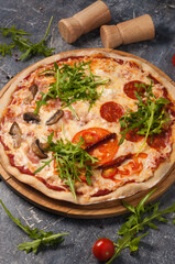 assorted pizza with different fillings: salami, tomatoes, mushrooms, bacon, sun-dried tomatoes. Vertical frame