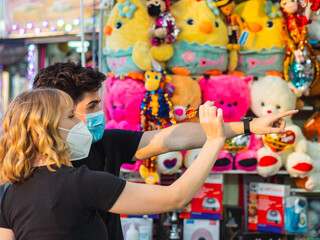 Obraz premium Pareja joven jugando en una tómbola de dardos explotando globos