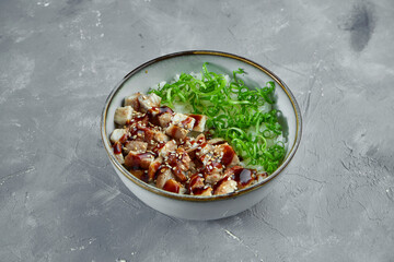 Traditional japanese dish - poke bowl with eel, rice and green onions on a gray background. Healthy superfood