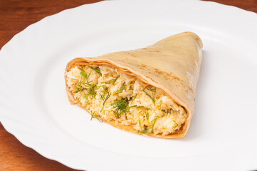 crepe with cheese, garlic and herbs on a white plate