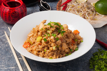 Asian fried garlic rice with chicken on a white plate. Horizontal frame