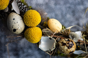 Close-Up of an Easter wreath decorated with quail eggs and feathers on a table