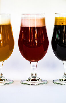 Three different glasses of craft beers lined up on a table