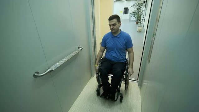 A man in a wheelchair enters the elevator. A person with a disability rides an elevator.