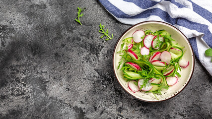 Healthy food nourishment diet detox dieting fresh vegetable salad of radish, cucumbers, arugula, vegan vegetarian food concept. Long banner format, top view