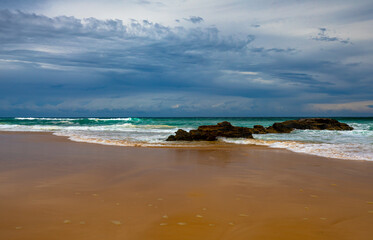 Landscapes Blue sky and waves  breaking on small rock formations and smooth sandy beach on Mid North Coast,NSW, Australia