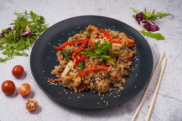 fried rice with vegetables on a black plate. Asian cuisine