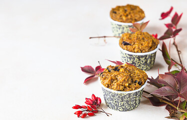 Healthy vegan homemade carrot or pumpkin muffins with raisin and nuts, light background. Copy space.