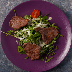 salad of fried beef, arugula and sauce. Top view