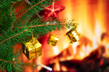 Christmas tree with toys on the background of a fireplace with fire