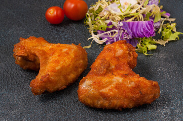 breaded chicken wings on a dark background