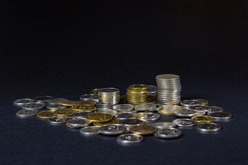 A stack of coins on a dark background in a close-up