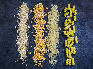 Set of carbohydrates on a blue background, rice, pasta, porridge, peas