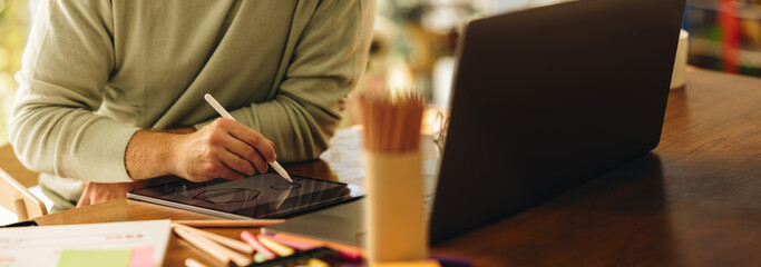 Artist drawing illustration on digital tablet