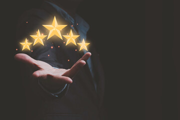 Businessman holding virtual five stars for customer feedback rating and evaluation concept.