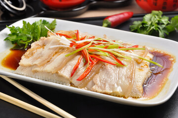 Asian cuisine: white fish with bacon in sauce