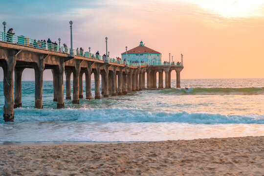 Fototapeta Manhattan beach pier at sunset, orange-pink sky with bright colors, beautiful landscape with ocean and sand